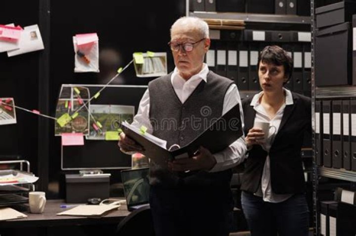 Detectives are looking at a case file on Law & Order: Trial by Jury.