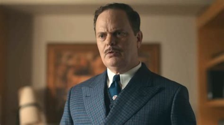 Rainn Wilson as Phil Lebensmal in Apple TV Lessons in Chemistry is talking to someone off camera.